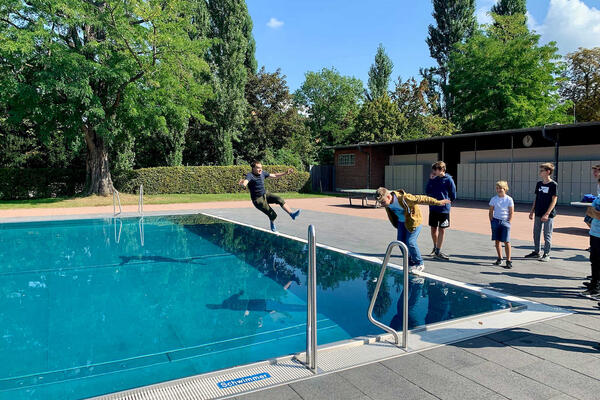 Jugendliche springen bekleidet ins Wasser